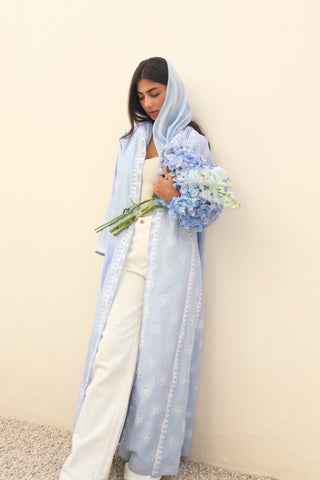 The Language Of Flowers S.FO1-an elegant powder blue abaya featuring delicate floral cutwork fabric and intricate white embroidery.