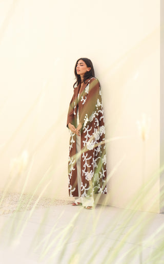 Shimmer-The Art of Layers S.LO4 - a luxurious brown abaya adorned with delicate white floral patches and elegant tassel details.