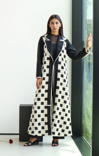The Art of Layers S.LO9 - an elegant black abaya featuring delicate white lace panels and refined white piping for a striking contrast. 