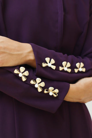 A captivating deep purple abaya, Letters From Kyoto S.KO2 features delicate gold floral details on the neckline and sleeves.