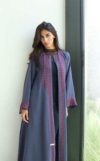 The Language Of Flowers S.FO7 is a sophisticated grey abaya enhanced with striking red geometric embroidery for a distinctive, contemporary finish.